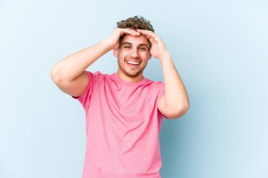 Sarışın, kıvırcık saçlı, beyaz tenli bir adam yalnız kahkahalar atıyor. Mutluluk kavramı.