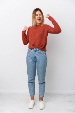 Zaferden sonra yumruğunu kaldıran beyaz bir kadın. Kazanan kavram..