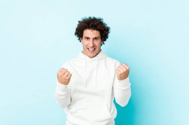 Mavi arka planda genç bir sporcu tasasız ve heyecanlı bir tezahürat yapıyor. Zafer konsepti.