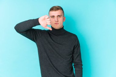 Mavi arka planda genç, beyaz bir adam hoşlanmadığı bir jest yapıyor, kabul etmiyor. Anlaşmazlık konsepti.