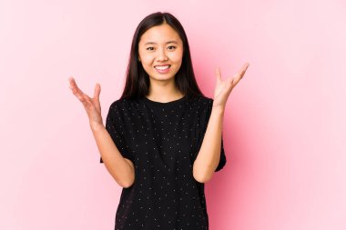 Young asian woman wearing elegant clothes isolated receiving a pleasant surprise, excited and raising hands.