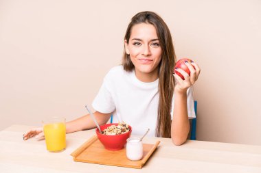 Genç beyaz kadın kahvaltı yapıyor.