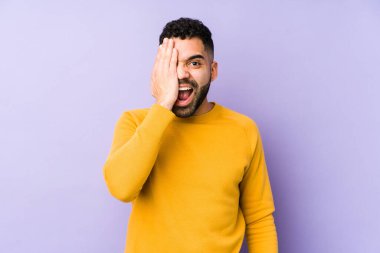 Genç, melez, yalıtılmış Arap bir adam yüzünün yarısını palmiye ile kaplayarak eğleniyor..