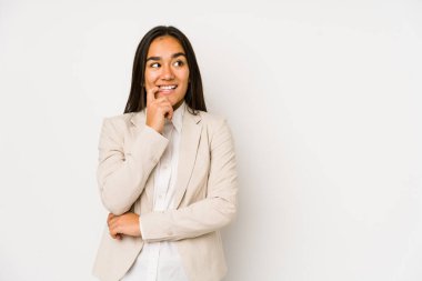 Young woman isolated on a white background relaxed thinking about something looking at a copy space.