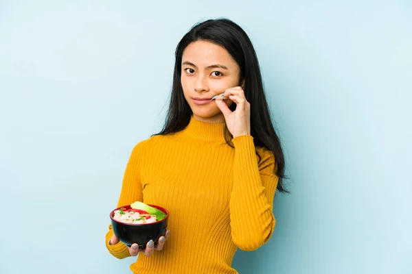 stock image Young chinese woman holding noodles isolated shrugs shoulders and open eyes confused.