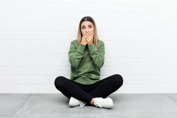 Young Caucasian Woman Sitting Floor Shocked Covering Mouth Hands — ストック写真