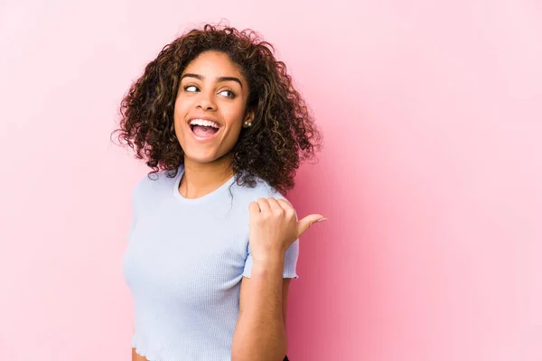 Joven Mujer Afroamericana Contra Fondo Rosa Apunta Con Dedo Pulgar —  Fotos de Stock