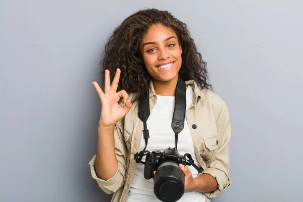 若いですアフリカ系アメリカ人の写真家女性を保持していますカメラ陽気で自信を持ってショーOkジェスチャー — ストック写真