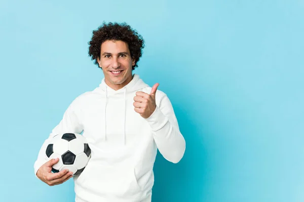 Αθλητικός Άνθρωπος Κρατώντας Μια Μπάλα Ποδοσφαίρου Χαμογελώντας Και Υψώνοντας Τον — Φωτογραφία Αρχείου