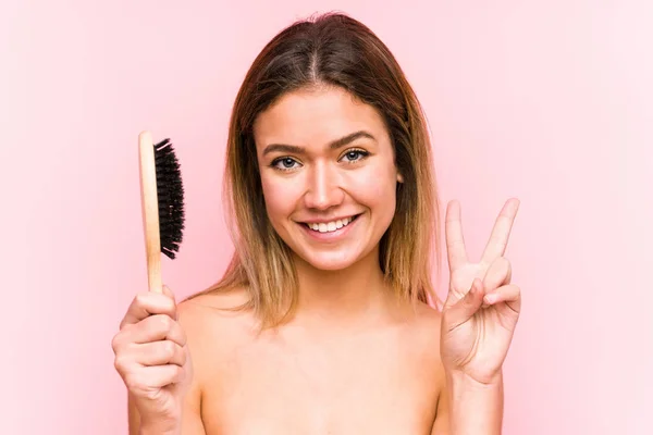 Joven Mujer Caucásica Sosteniendo Cepillo Aislado Mostrando Signo Victoria Sonriendo —  Fotos de Stock