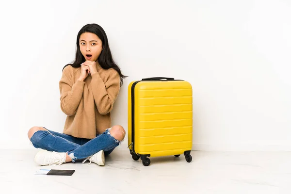 若い中国人旅行者の女性が座っています床にスーツケースで隔離された祈り運 口を開けて前を見て — ストック写真