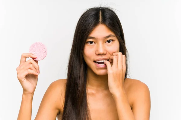 Young Chinese Woman Holding Facial Disk Isolated Biting Fingernails Nervous — Stock Photo, Image