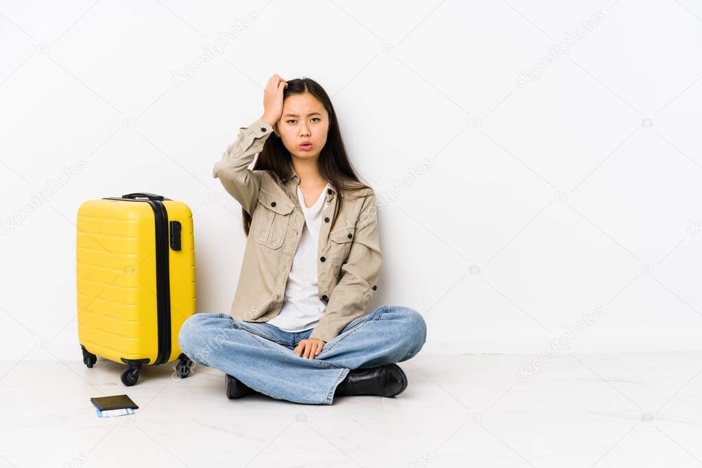 Young chinese traveler woman sitting holding a boarding passes tired and very sleepy keeping hand on head.