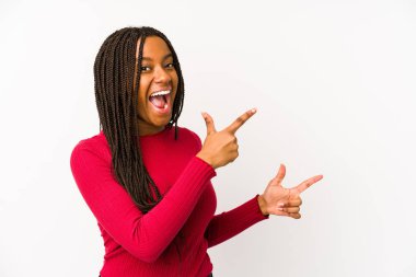 Young african american woman isolated pointing with forefingers to a copy space, expressing excitement and desire. clipart