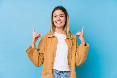 Kafkasyalı genç bir kadın, iki elini de havaya kaldırarak boş bir alan gösterdiğini gösteriyor..