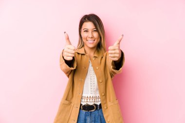 Kafkasyalı genç bir kadın başparmağıyla izole poz veriyor, bir şey için tezahürat yapıyor, destek ve saygı kavramı..