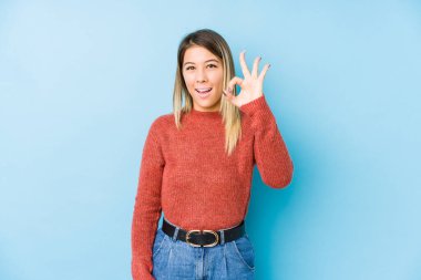 Kafkasyalı genç bir kadın yalnız poz veriyor neşeli ve kendinden emin, iyi bir hareket gösteriyor..