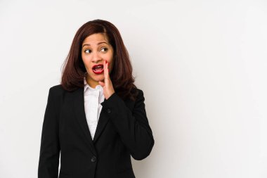 Middle age latin business woman isolated is saying a secret hot braking news and looking aside