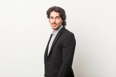 Beyaz bir geçmişi olan genç bir iş adamı gülümseyen, neşeli ve keyifli bir kenara bakar..