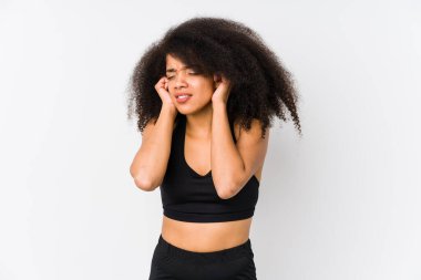 Young african american sporty woman covering ears with hands.