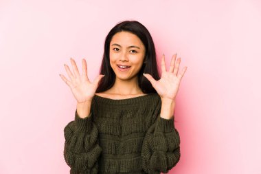 Young chinese woman isolated on a pink background showing number ten with hands.