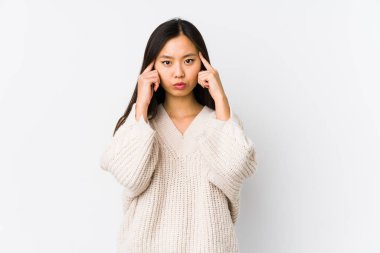Young chinese woman isolated focused on a task, keeping forefingers pointing head.
