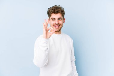 Sarışın, kıvırcık saçlı, beyaz tenli, neşeli ve kendinden emin bir adam..