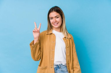 Genç beyaz kadın iki numarayı parmaklarıyla gösteriyor..