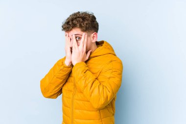 Sarışın, kıvırcık saçlı, beyaz tenli, izole bir adam parmaklarıyla gözünü kırp korkmuş ve gergin..