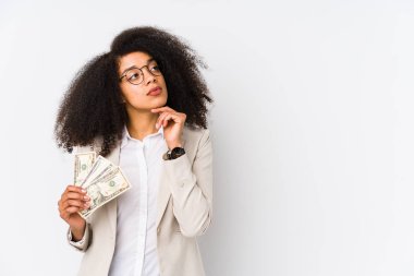 Kredi kartı tutan genç afro iş kadını, şüpheli ve şüpheci bir ifadeyle kredi kartı taşıyan genç afro iş kadınını izole etti..