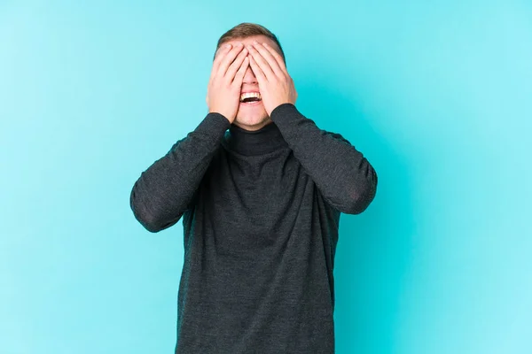 Jonge Blanke Man Een Blauwe Achtergrond Bedekt Ogen Met Handen — Stockfoto