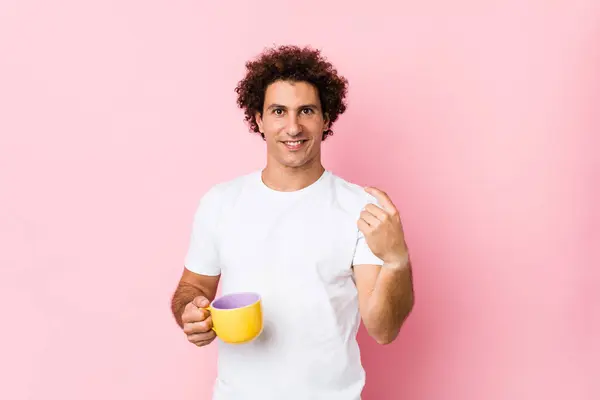 Homem Encaracolado Caucasiano Jovem Segurando Uma Xícara Chá Apontando Com — Fotografia de Stock