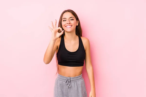 Joven Caucásico Fitness Mujer Posando Fondo Rosa Alegre Confiado Mostrando —  Fotos de Stock