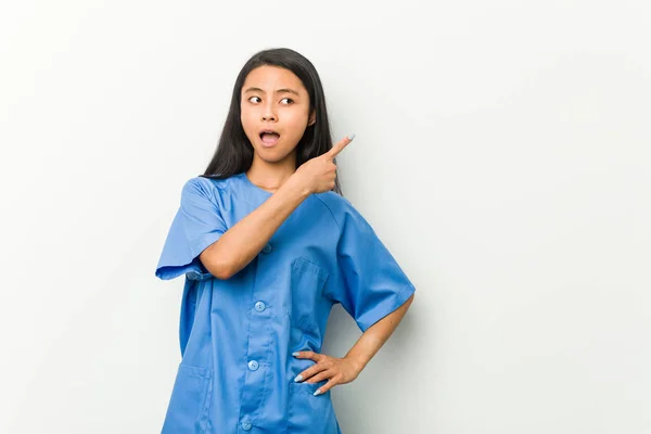 Νεαρή Ασιάτισσα Νοσοκόμα Που Δείχνει Πλάι — Φωτογραφία Αρχείου