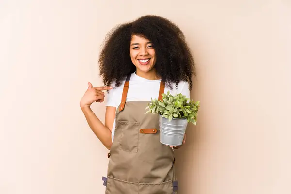 Jovem Jardineira Afro Segurando Uma Planta Isoladapessoa Apontando Mão Para — Fotografia de Stock