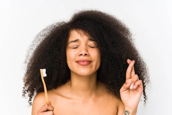 Jovem Afro Mulher Segurando Uma Escova Dentes Isolado Cruzando Dedos — Fotografia de Stock