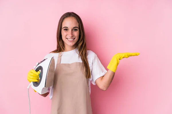 Young Caucasian Woman Clothes Iron Isolated Showing Copy Space Palm — Stock Photo, Image