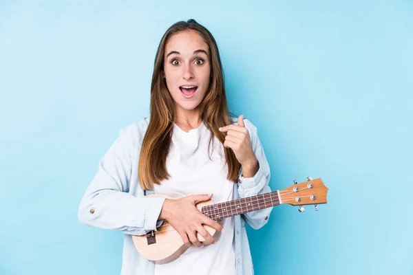 Young Caucasian Woman Holding Ukelele Isolated Surprised Pointing Himself Smiling — 图库照片