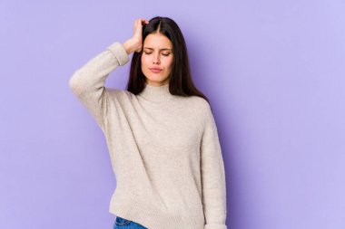 Mor arka planda izole edilmiş genç beyaz kadın yorgun ve uykulu ellerini başının üstünde tutuyor..