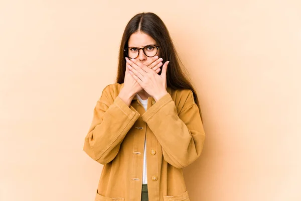 Ung Kaukasisk Kvinna Isolerad Beige Bakgrund Täcker Munnen Med Händerna — Stockfoto