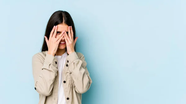 Junge Kaukasische Frau Auf Blauem Hintergrund Blinzelt Durch Die Finger — Stockfoto