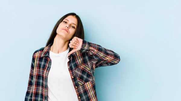 年轻的高加索女人被蓝色背景隔离 表现出不喜欢的姿态 低垂大拇指 不同意的概念 — 图库照片