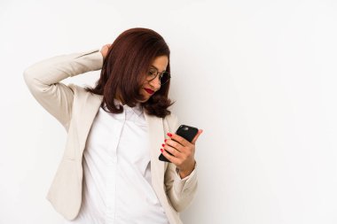 Orta yaşlı Latin bir kadın cep telefonu tutuyor. Kafasının arkasına dokunuyor, düşünüyor ve bir seçim yapıyor..