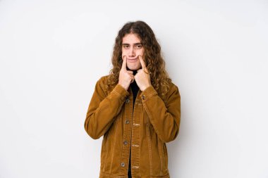 Uzun saçlı adam iki seçenek arasında kuşkuyla poz veriyor..