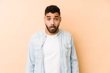 Genç, melez, Arap bir adam omuz silkiyor ve gözleri açık..