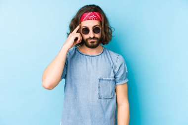 Genç, uzun saçlı, festival hippisi gibi giyinmiş, soyutlanmış, parmağıyla işaret eden, düşünen, bir göreve odaklanmış bir adam..