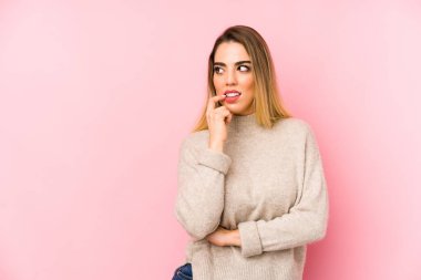 Middle age woman over isolated background relaxed thinking about something looking at a copy space.