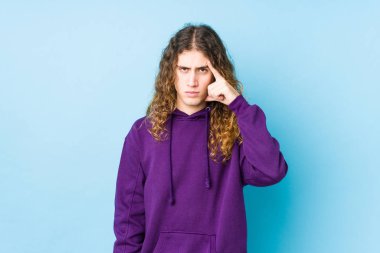 Uzun saçlı adam kendini soyutlamış, parmağıyla işaret ediyor, düşünüyor ve bir göreve odaklanıyor..