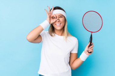 Badminton oynayan beyaz bir kadın heyecanlı. Gözünü dört aç..