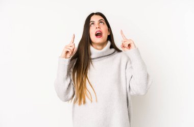 Beyaz arka planda izole edilmiş beyaz bir kadın ağzı açık bir şekilde üst tarafı işaret ediyor..